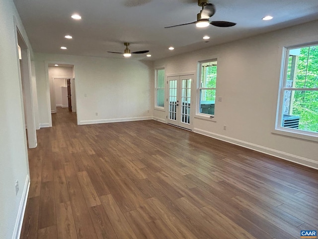 empty room featuring french doors, ceiling fan, and dark wood-type flooring