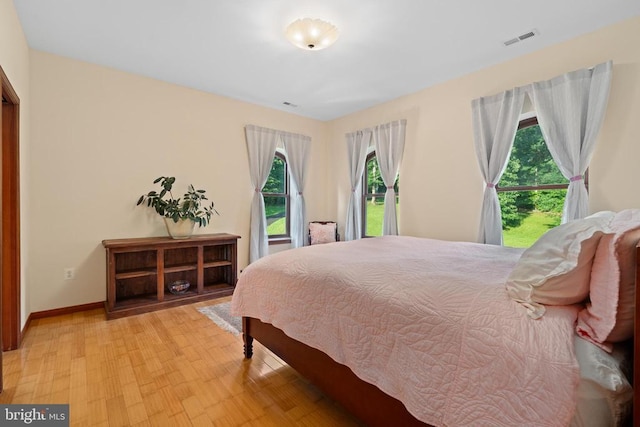 bedroom featuring multiple windows and light hardwood / wood-style floors