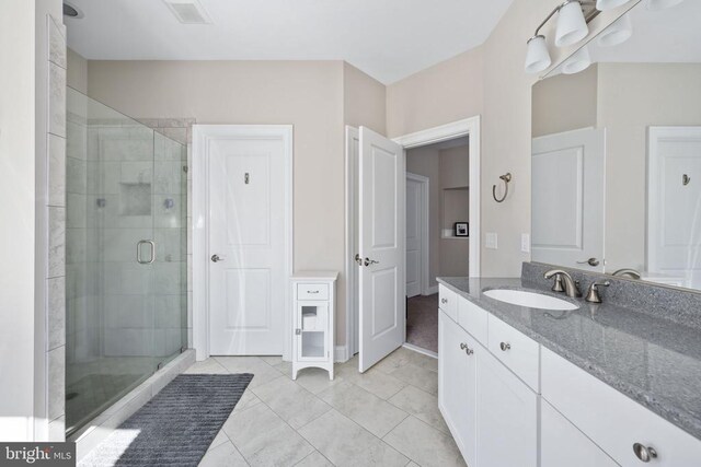 bathroom with vanity, tile patterned flooring, and a shower with shower door