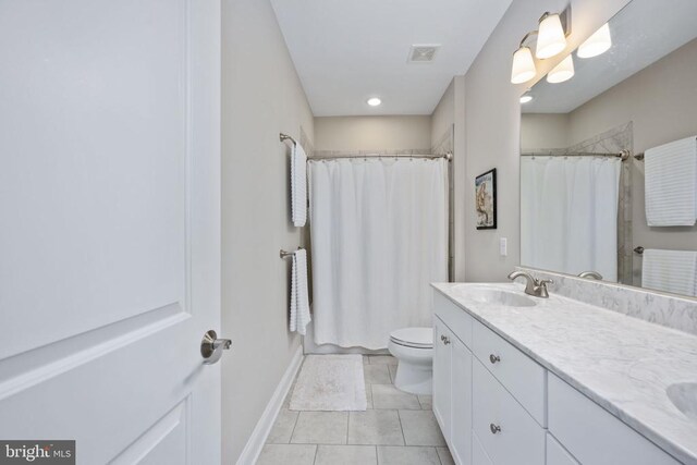 bathroom with vanity, tile patterned flooring, toilet, and walk in shower