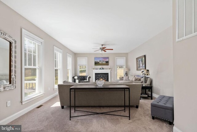 carpeted living room with ceiling fan