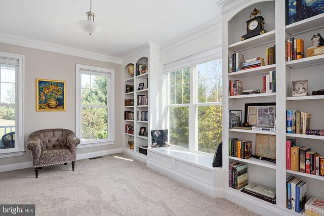 living area with built in features, crown molding, a wealth of natural light, and light colored carpet