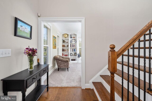 stairs featuring wood-type flooring and built in features