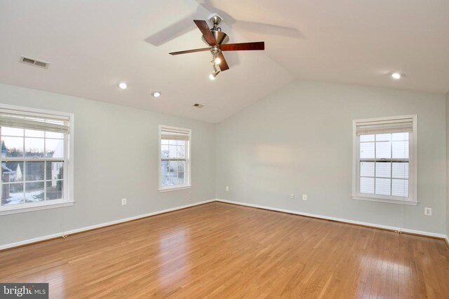 empty room with ceiling fan, lofted ceiling, and light hardwood / wood-style flooring