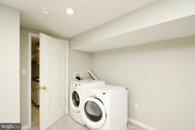 washroom featuring light carpet and washer and dryer