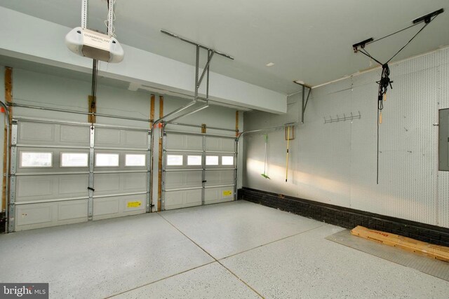 garage with a garage door opener and electric panel