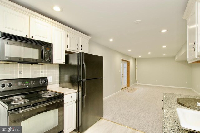 kitchen with white cabinetry, light stone counters, tasteful backsplash, black appliances, and light colored carpet