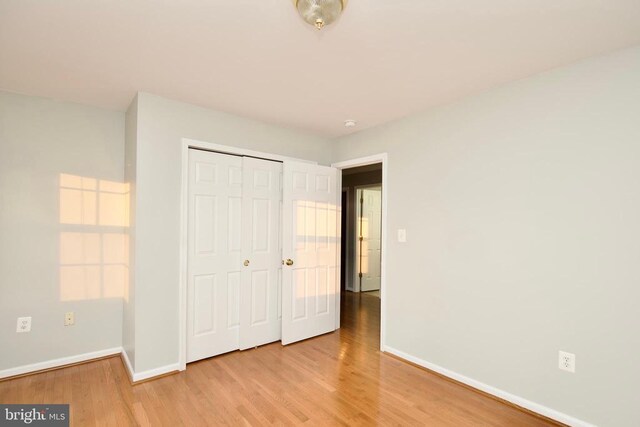 unfurnished bedroom featuring a closet and light wood-type flooring