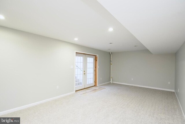 empty room featuring french doors and light colored carpet