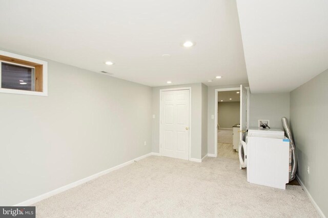 basement with light colored carpet and washer / clothes dryer