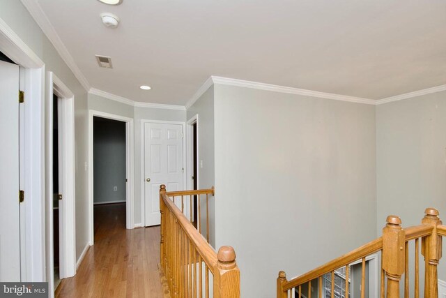 hall with crown molding and light wood-type flooring