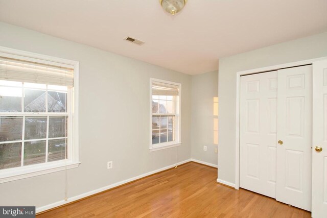 unfurnished bedroom featuring a closet and light hardwood / wood-style flooring