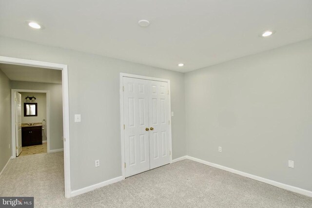 unfurnished bedroom featuring light colored carpet and a closet