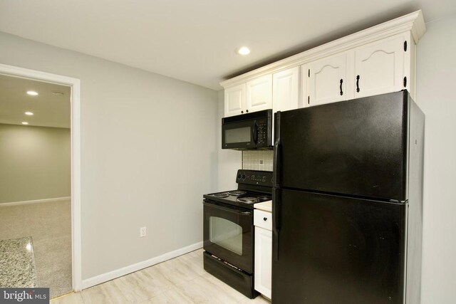 kitchen with tasteful backsplash, white cabinetry, and black appliances