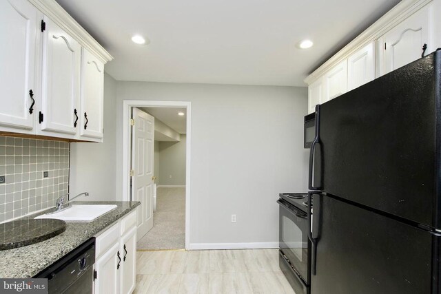 kitchen with sink, light stone counters, black appliances, backsplash, and white cabinets