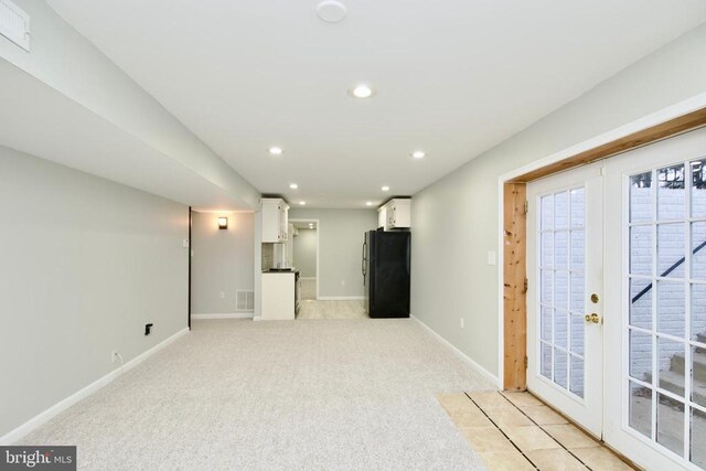 basement featuring black fridge, light colored carpet, and french doors