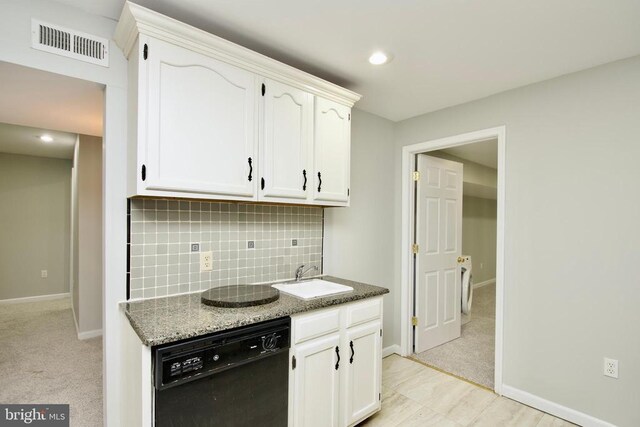 kitchen featuring sink, white cabinetry, stone countertops, black dishwasher, and backsplash