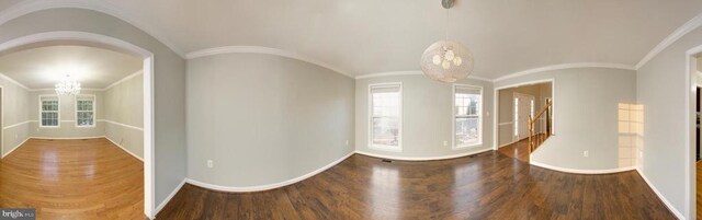 empty room with hardwood / wood-style flooring, lofted ceiling, a chandelier, and plenty of natural light