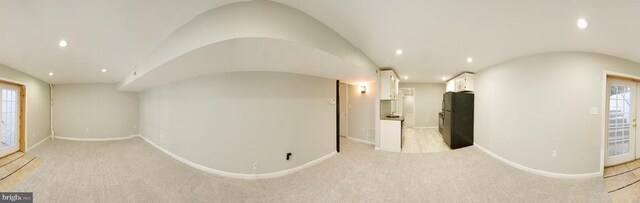 interior space with lofted ceiling and light colored carpet