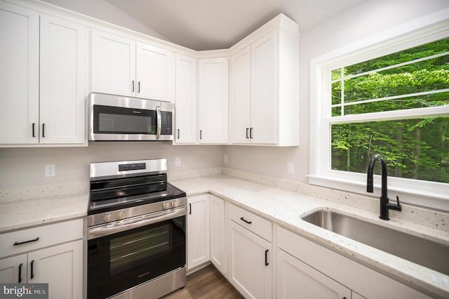 kitchen with stainless steel appliances, sink, and white cabinets