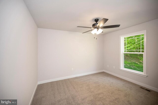 carpeted spare room with ceiling fan