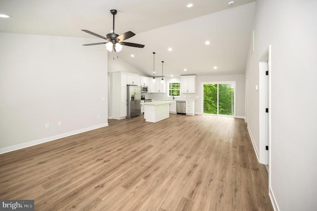 unfurnished living room with high vaulted ceiling, light hardwood / wood-style floors, and ceiling fan