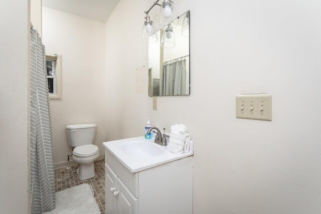 bathroom featuring tile patterned flooring, vanity, and toilet