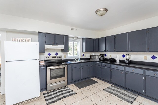 kitchen featuring stainless steel appliances, sink, light tile patterned floors, and decorative backsplash