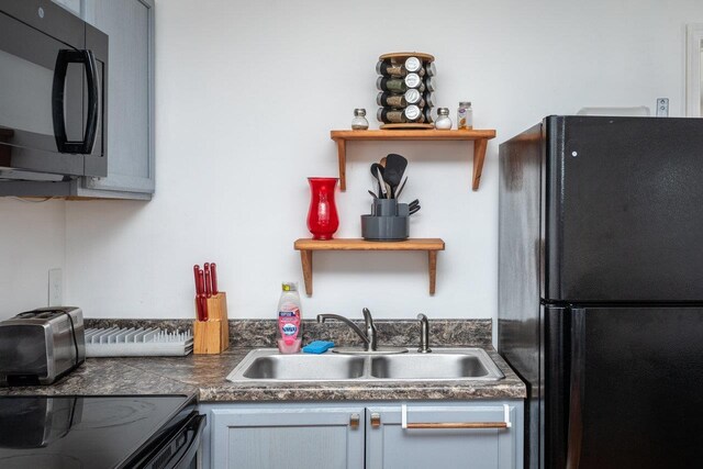 kitchen with gray cabinetry, sink, and black appliances