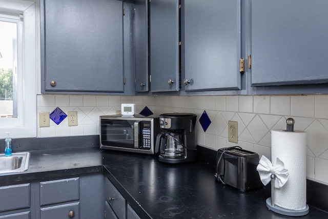 kitchen featuring gray cabinetry, sink, and backsplash