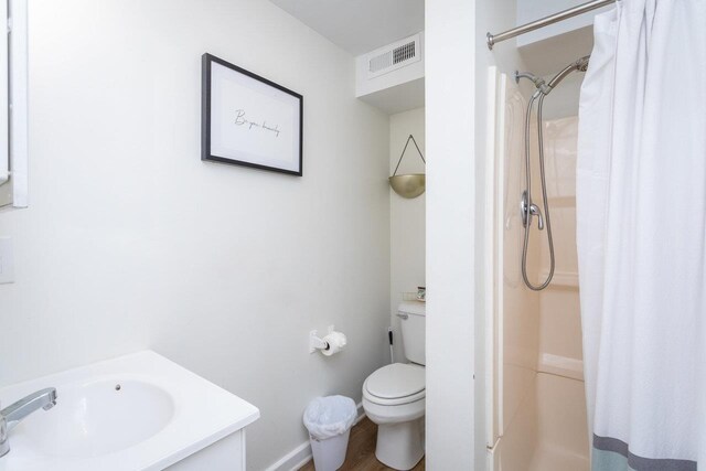 bathroom featuring a shower with curtain, toilet, and sink