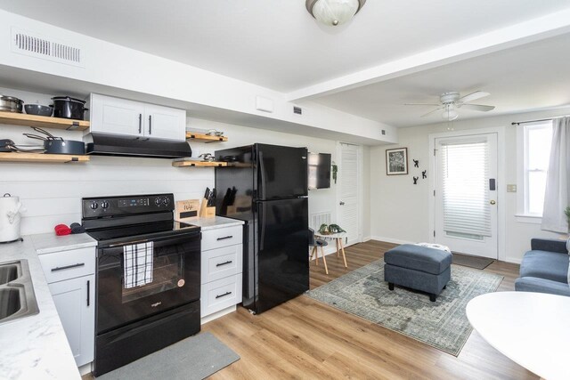 kitchen with white cabinetry, sink, light hardwood / wood-style floors, and black appliances