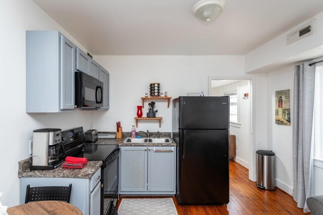 kitchen featuring gray cabinets, sink, hardwood / wood-style floors, and black appliances