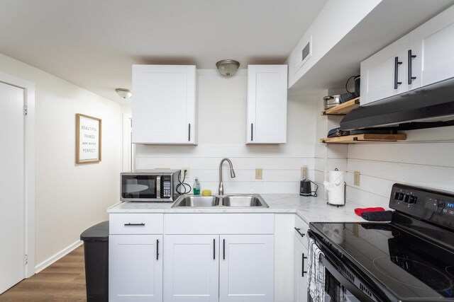 kitchen with black range with electric stovetop, ventilation hood, sink, and white cabinets