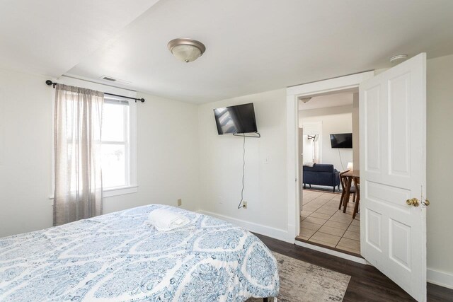 bedroom with dark wood-type flooring