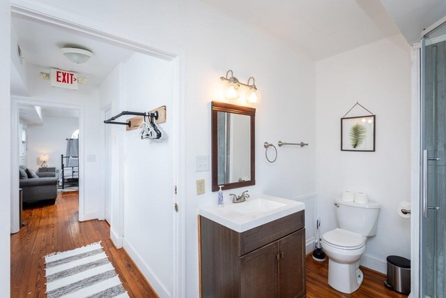 bathroom featuring wood-type flooring, vanity, and toilet