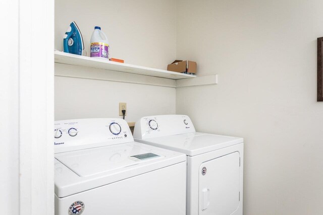 clothes washing area with washing machine and dryer