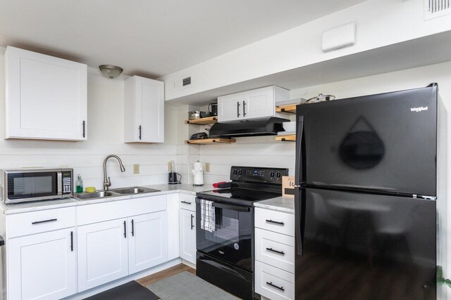 kitchen featuring sink, white cabinetry, hardwood / wood-style flooring, decorative backsplash, and black appliances
