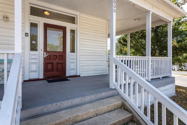 view of exterior entry featuring covered porch