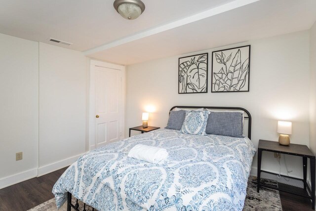 bedroom with dark wood-type flooring