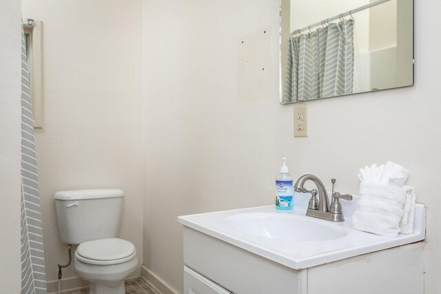 bathroom with a shower with curtain, vanity, and toilet
