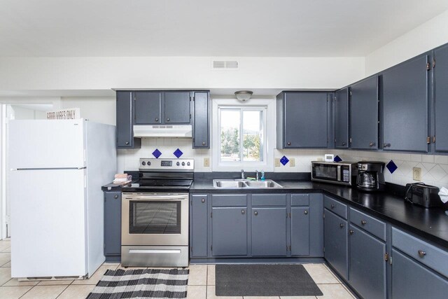 kitchen with white fridge, sink, decorative backsplash, and stainless steel electric range
