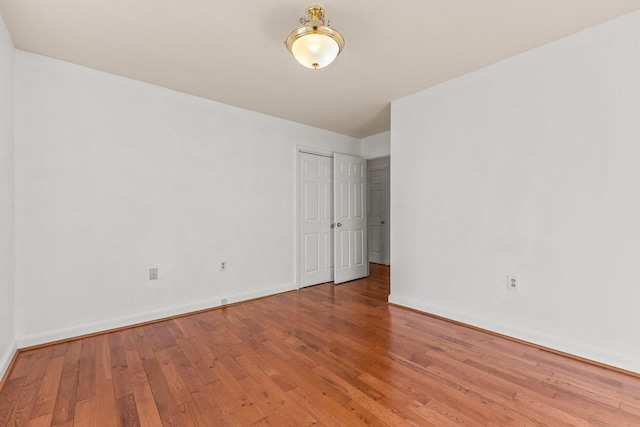 unfurnished room featuring baseboards and light wood finished floors