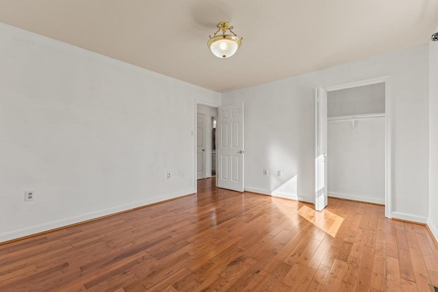 unfurnished bedroom with a closet, light wood-style flooring, and baseboards