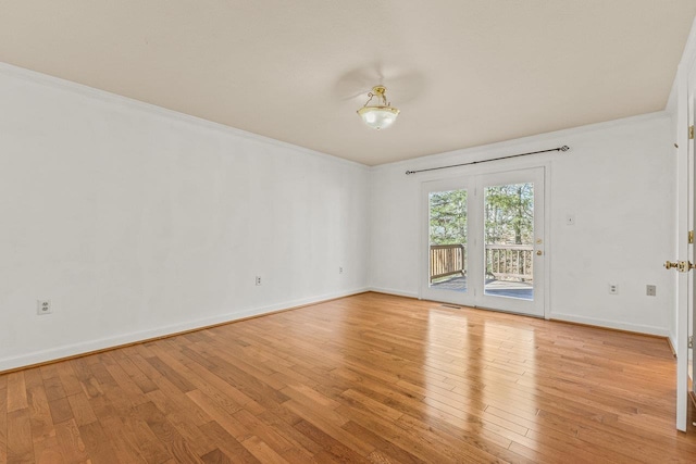 empty room with baseboards, light wood-style floors, and ornamental molding