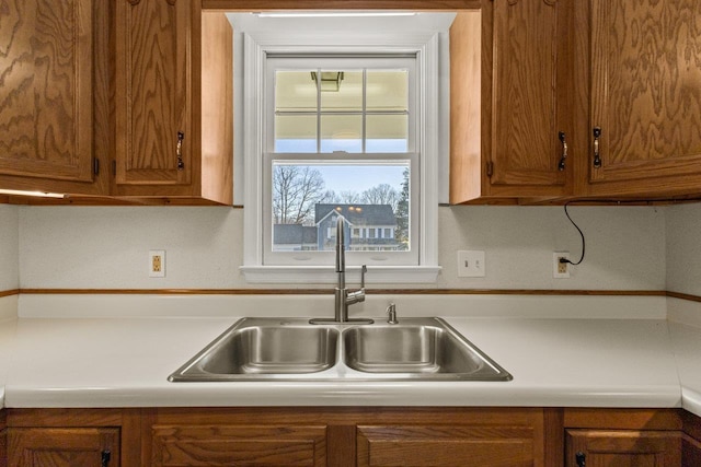 kitchen featuring a sink, brown cabinetry, and light countertops