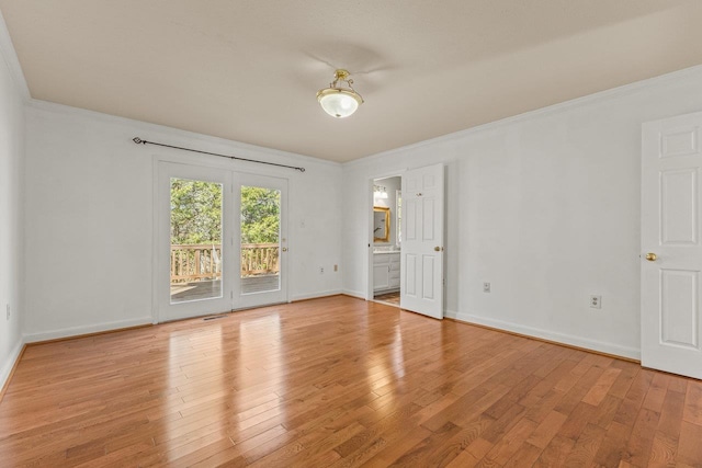 unfurnished room featuring light wood-style flooring, crown molding, and baseboards