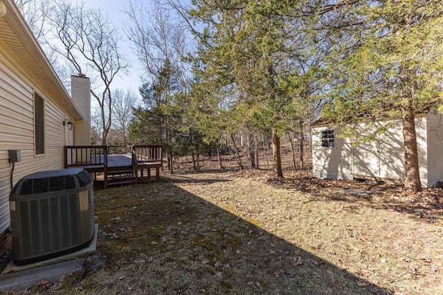 view of yard with cooling unit, an outdoor structure, and a deck