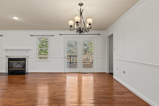 unfurnished dining area featuring crown molding, wood finished floors, and baseboards