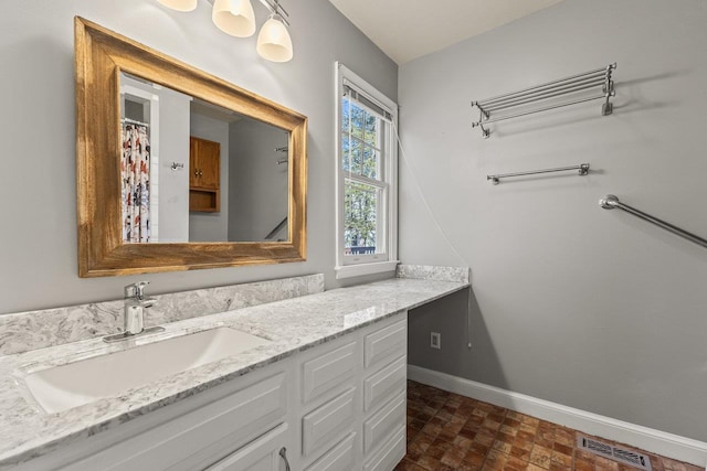 bathroom with vanity, a shower with curtain, visible vents, baseboards, and brick floor